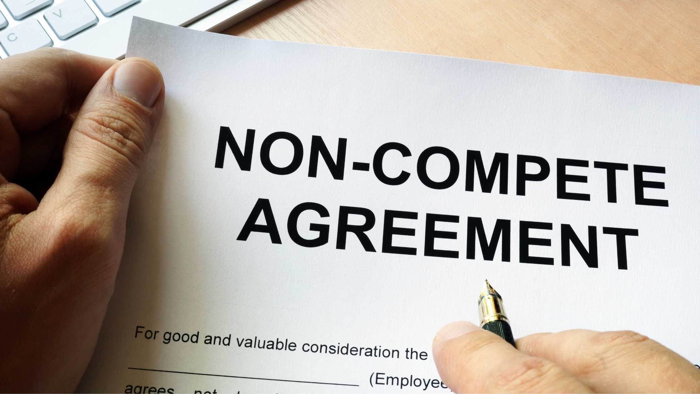 Close-up of a non-compete agreement document with a pen poised for signature, highlighting enforceability
