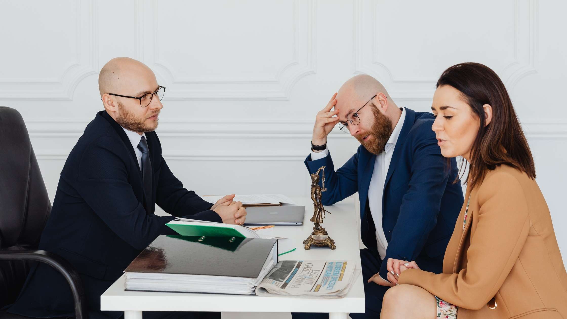 Lawyer speaking to clients across a desk about an arbitration agreement